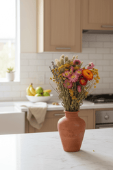 Ramo campestre assecat de tons multicolors en una bonica testera en una cuina lluminosa