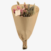 Ramo campestre sec en tons rosats en paper kraft sobre un fons blanc